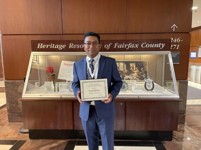 Senior Inspector Shyam Bajimaya, CMIT holding a Tam Excellence award for work on Scott's Run Trail Project.