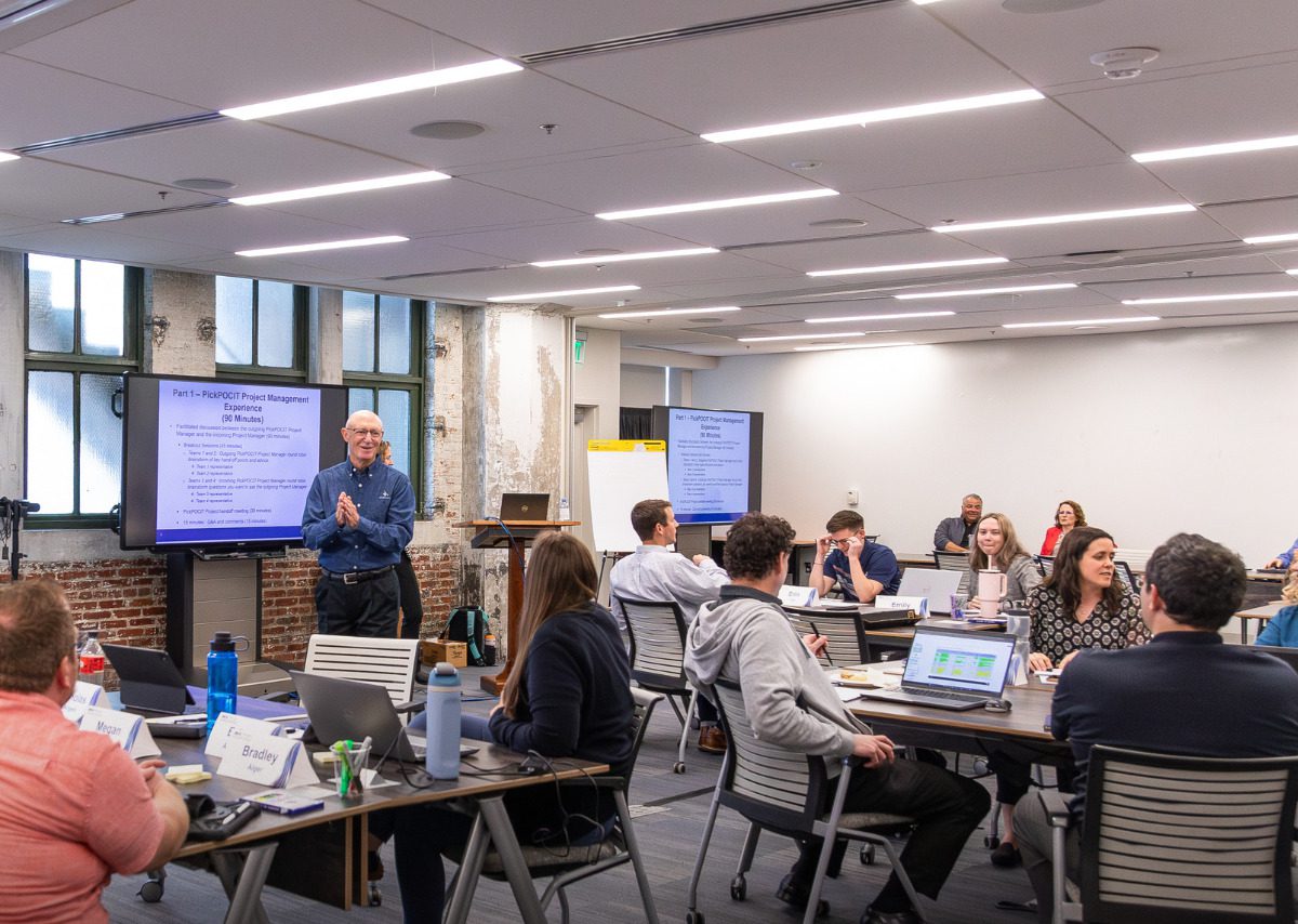 An instructor telling students about the project.