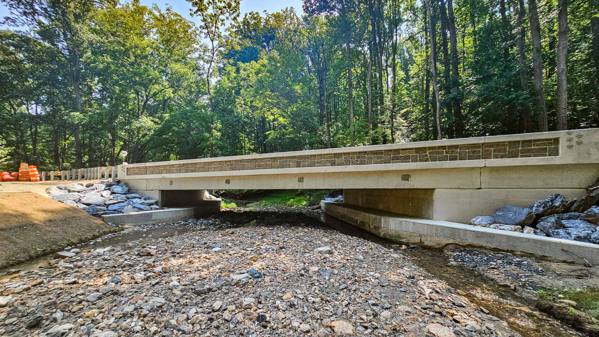 Finished Henryton Road Bridge over a rocky stream in a wooded area.