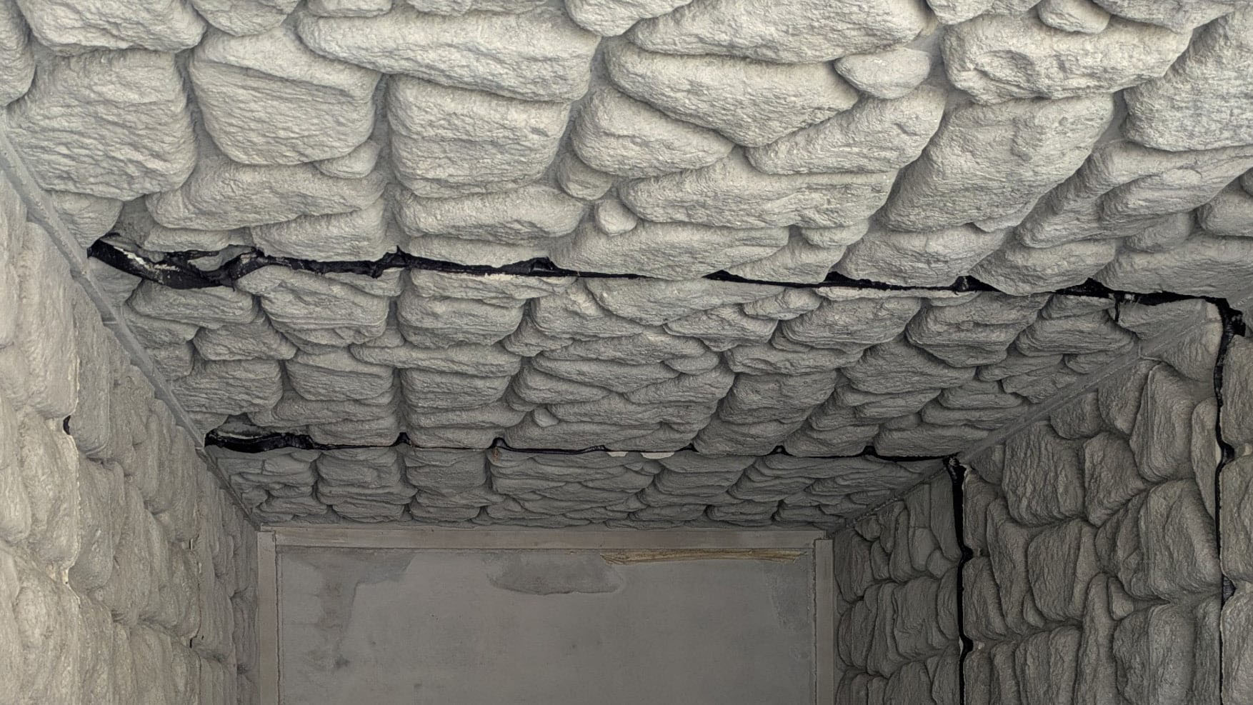 Interior of a bat hibernaculum with textured walls and ceiling creating roosting crevices for bats.
