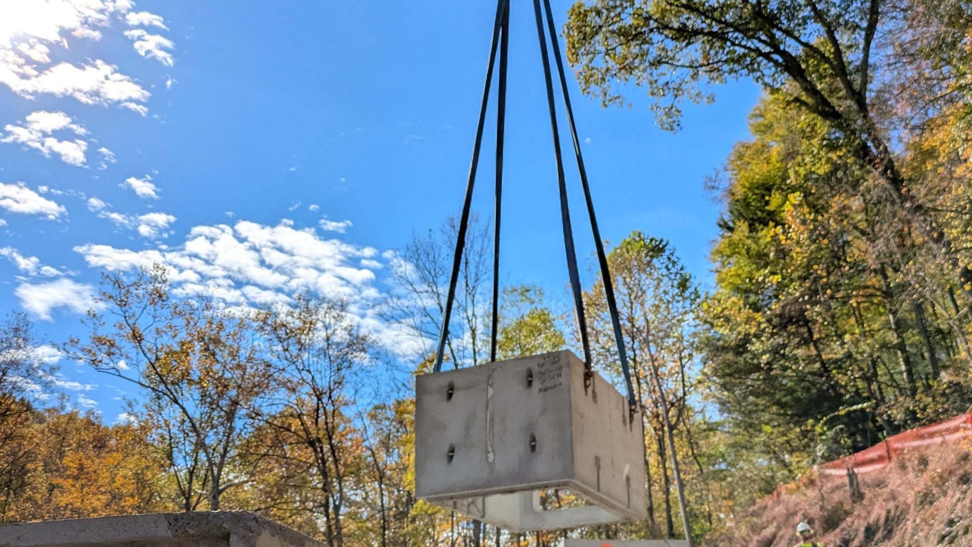 Crane lowers a concrete entrance section into place for a bat hibernaculum.